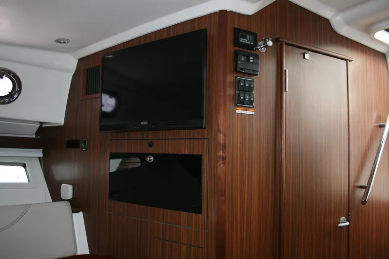 Skye Boat Yacht Photos Pics 2020 Pursuit OS 355 Offshore cabin interior with TV and control panel.