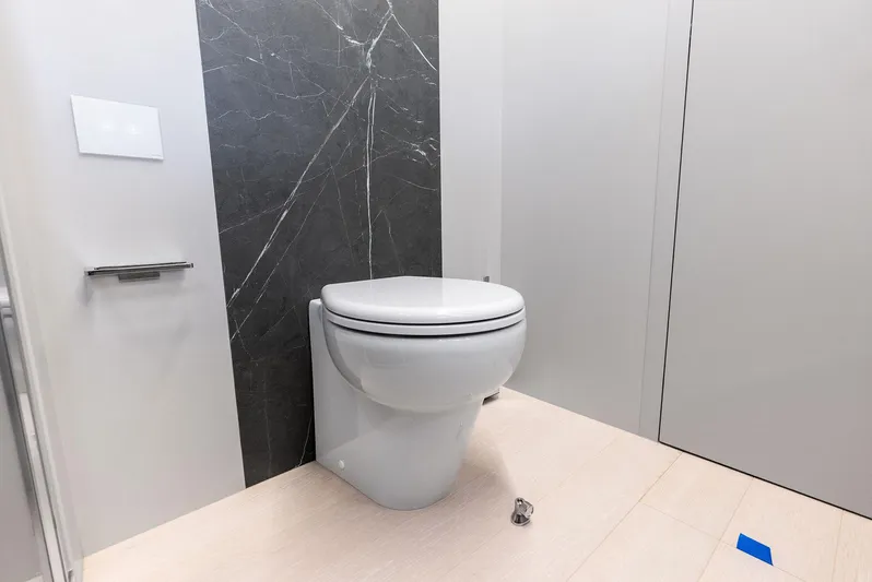 Barnext Yacht Photos Pics Modern bathroom with sleek toilet design, featuring marble accent wall and minimalist decor.