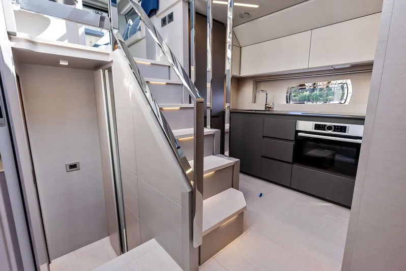 Barnext Yacht Photos Pics Luxurious interior of 2025 Pershing 7X yacht with modern kitchen and sleek staircase.