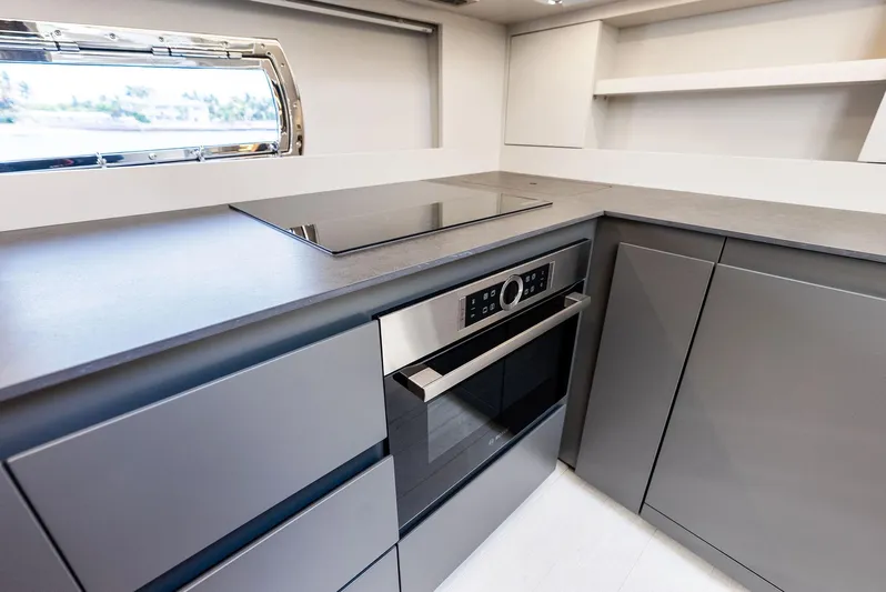 Barnext Yacht Photos Pics Modern kitchen interior on Pershing 7X yacht, featuring sleek cabinetry and built-in appliances, 2025 model.