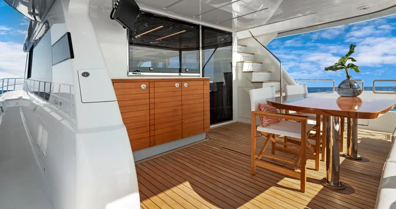 Clb65 Yacht Photos Pics 2024 CL Yachts CLB65 yacht deck with dining area, wooden cabinetry, and ocean view.