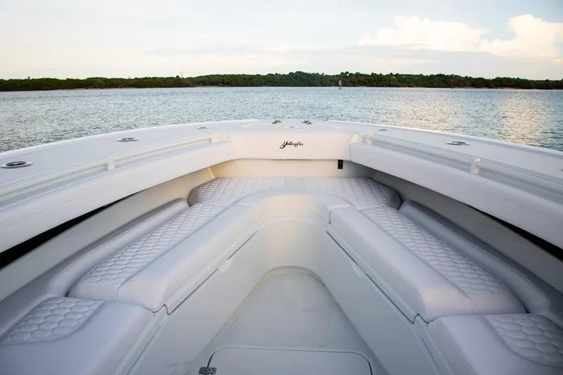 New Stock Yacht Photos Pics 2026 Yellowfin 36 Offshore boat interior with white cushioned seating on calm water.