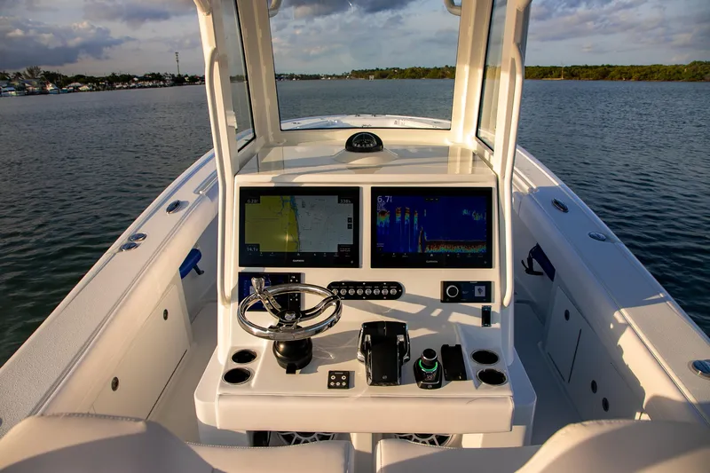 New Stock Yacht Photos Pics 2026 Yellowfin 36 Offshore boat dashboard with navigation screens on calm water.