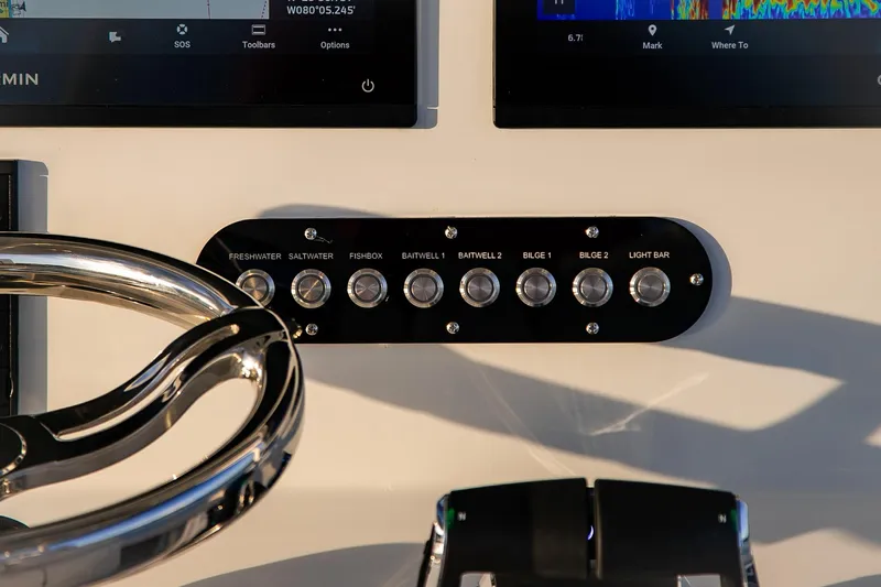 New Stock Yacht Photos Pics Control panel of 2026 Yellowfin 36 Offshore boat with steering wheel and switches.