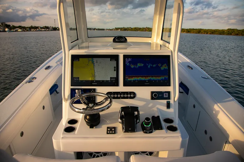 New Stock Yacht Photos Pics 2026 Yellowfin 36 Offshore boat dashboard with dual navigation screens on calm water.