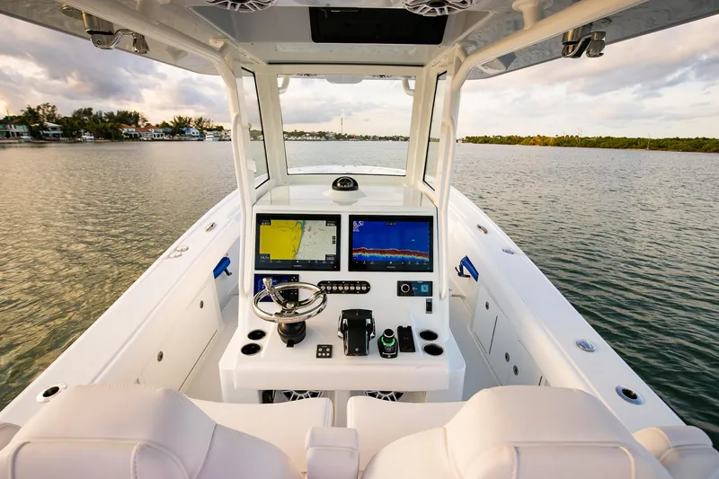 New Stock Yacht Photos Pics 2026 Yellowfin 36 Offshore boat cockpit with advanced navigation systems on calm water.