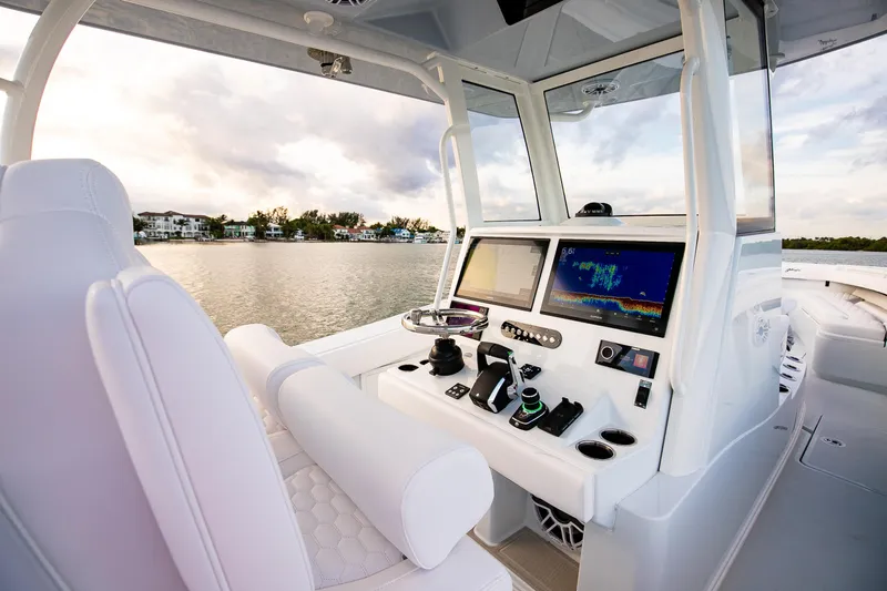 New Stock Yacht Photos Pics 2026 Yellowfin 36 Offshore boat cockpit with advanced navigation systems on a serene water backdrop.