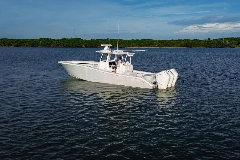 New Stock Yacht Photos Pics 2026 Yellowfin 36 Offshore boat on calm water with triple outboard engines.