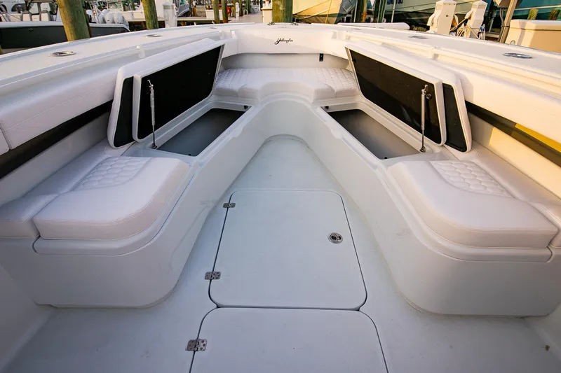 New Stock Yacht Photos Pics 2026 Yellowfin 36 Offshore boat interior with white cushioned seating and storage compartments.