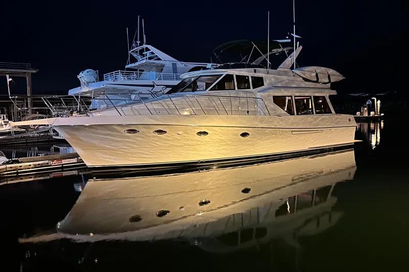  Yacht Photos Pics 1997 McKinna 48 Pilothouse yacht illuminated at night, reflecting on calm water.