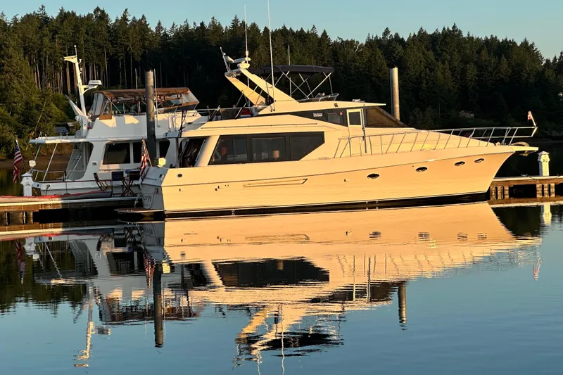  Yacht Photos Pics 1997 McKinna 48 Pilothouse yacht docked on calm water, reflecting trees and sky.