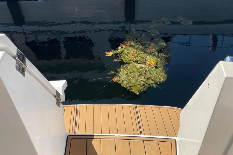  Yacht Photos Pics Stern view of 1997 McKinna 48 Pilothouse with floating debris in water.