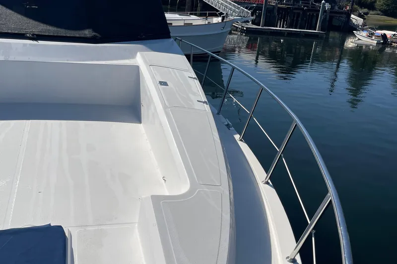  Yacht Photos Pics 1997 McKinna 48 Pilothouse yacht deck with railing, docked by calm water.