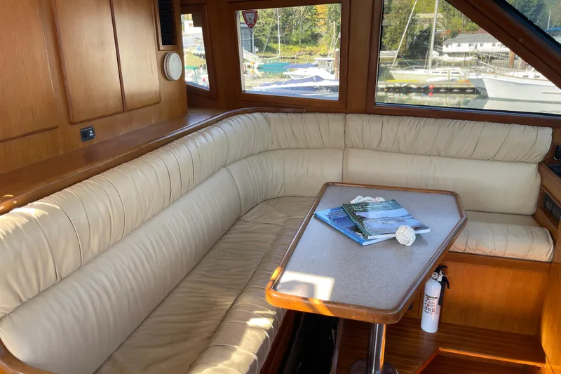 Yacht Photos Pics Interior of 1997 McKinna 48 Pilothouse with cream leather seating and table.