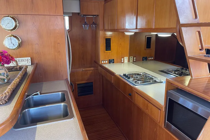  Yacht Photos Pics Luxurious 1997 McKinna 48 Pilothouse yacht kitchen with wood cabinetry and modern appliances.