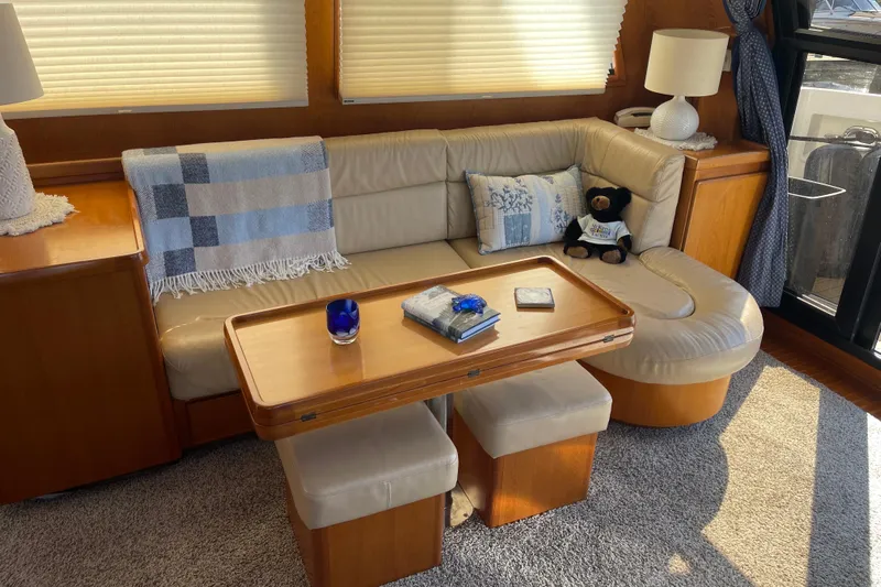  Yacht Photos Pics Cozy interior of 1997 McKinna 48 Pilothouse with plush seating and wooden table.