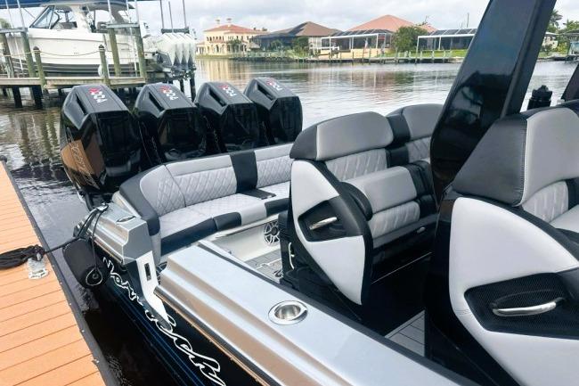 2025 Nor-Tech 400 Supersport boat with luxurious seating and powerful engines docked by the water.