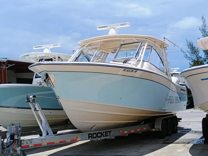 335-714 Used Yacht Photos Pics 2021 Grady-White Freedom 335 boat on trailer, parked outdoors under clear sky.