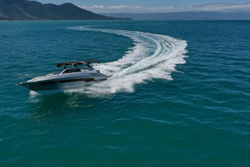 Custom Order Yours Today! Yacht Photos Pics 2025 Hanover 305 Inboard cruising on open sea with scenic mountain backdrop.