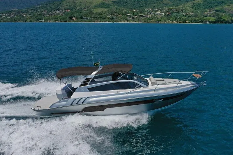 Custom Order Your 305 Today! Yacht Photos Pics 2025 Hanover 305 Inboard boat cruising on blue ocean with scenic mountain backdrop.