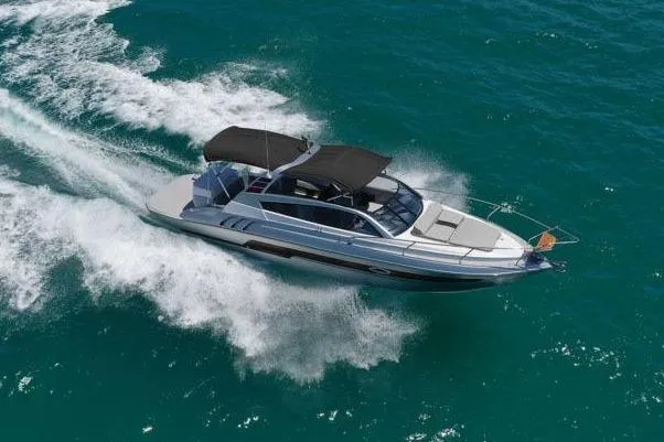 Custom Order Your 305 Today! Yacht Photos Pics 2025 Hanover 305 Inboard boat cruising on clear blue water, leaving a white wake trail.