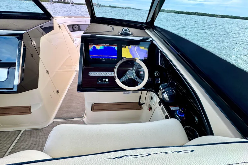  Yacht Photos Pics 2021 Chris-Craft Calypso 35 helm with navigation screens, steering wheel, and ocean view.
