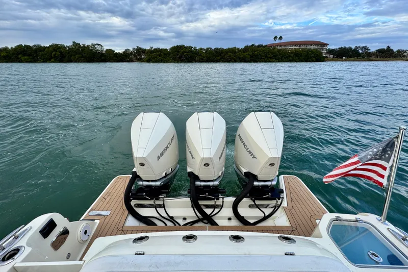  Yacht Photos Pics 2021 Chris-Craft Calypso 35 with triple Mercury engines and American flag on water.