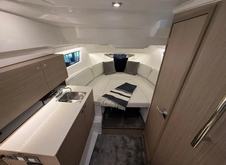  Yacht Photos Pics Interior of 2025 Jeanneau Leader 9.0 WA, featuring modern kitchenette and cozy seating area.