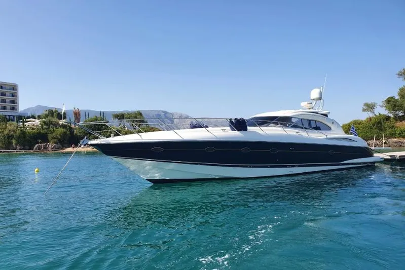  Yacht Photos Pics 2000 Sunseeker Predator 56 yacht anchored in clear blue water, scenic coastal backdrop.