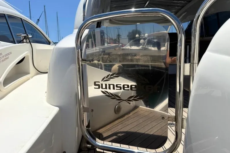  Yacht Photos Pics Sunseeker Predator 56 yacht, 2000 model, docked with reflective logo on metal gate.