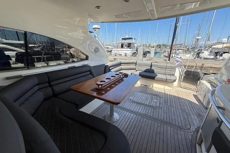  Yacht Photos Pics Luxurious Sunseeker Predator 56 yacht interior with elegant seating and wooden table, docked at marina.