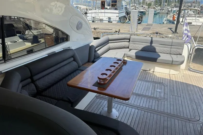  Yacht Photos Pics Sunseeker Predator 56 yacht interior, featuring elegant seating and a wooden table, docked at a marina.