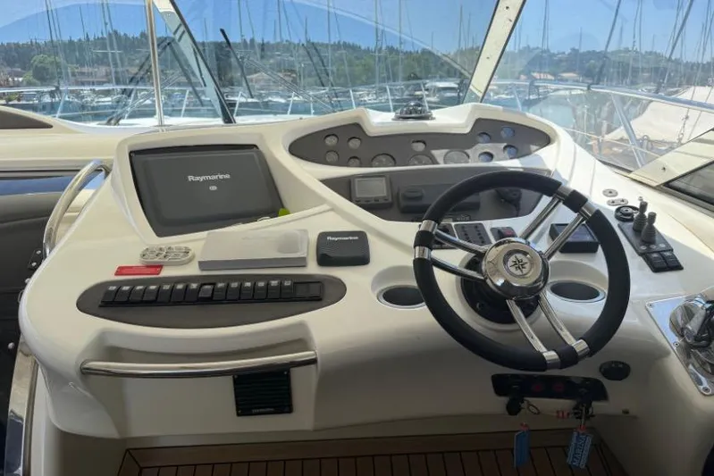  Yacht Photos Pics Control panel of a 2000 Sunseeker Predator 56 yacht with steering wheel and navigation equipment.
