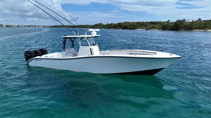  Yacht Photos Pics 2017 Yellowfin 36 Offshore boat on clear blue water, with fishing rods and triple engines.