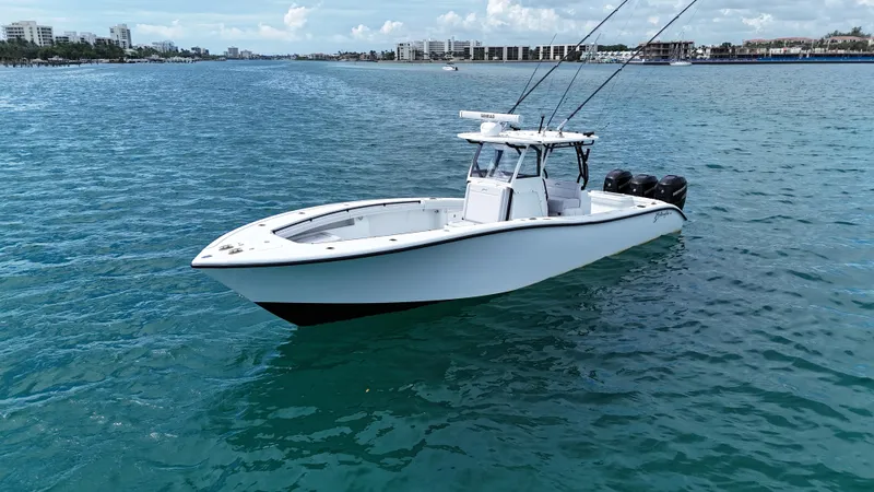  Yacht Photos Pics 2017 Yellowfin 36 Offshore boat on calm blue water, cityscape in background.