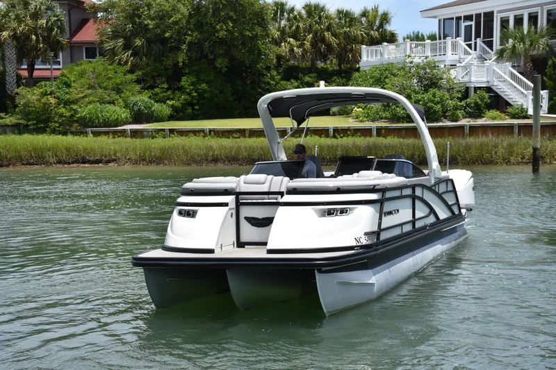  Yacht Photos Pics 2024 Bennington 27 QFB pontoon boat cruising on a scenic waterway.
