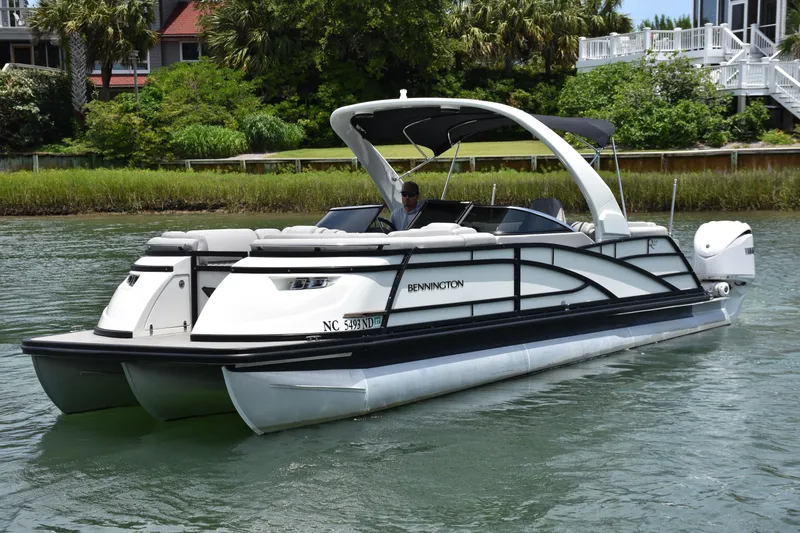 Yacht Photos Pics 2024 Bennington 27 QFB pontoon boat cruising on a scenic waterway.