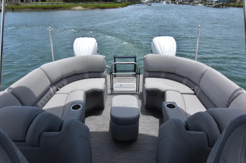  Yacht Photos Pics 2024 Bennington 27 QFB pontoon boat with luxurious seating on a serene waterway.