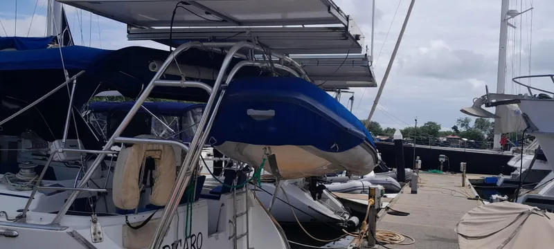 Picaro Yacht Photos Pics Beneteau Oceanis 473 sailboat docked, featuring a blue canopy and dinghy, 2005 model.