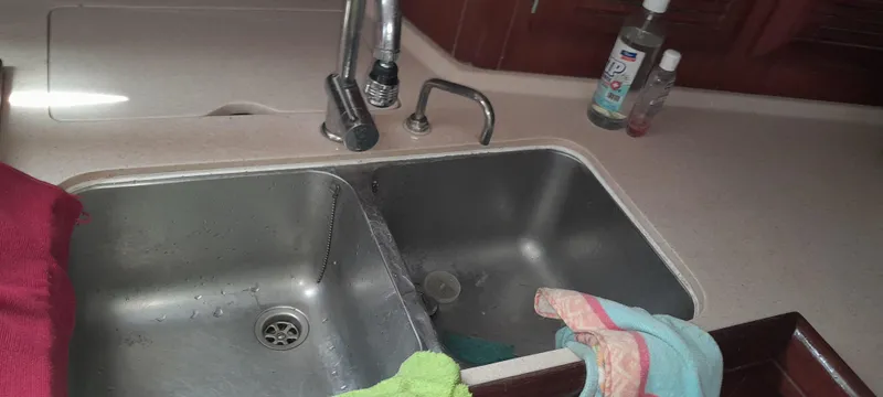Picaro Yacht Photos Pics Kitchen sink area on a 2005 Beneteau Oceanis 473 yacht with cleaning supplies.