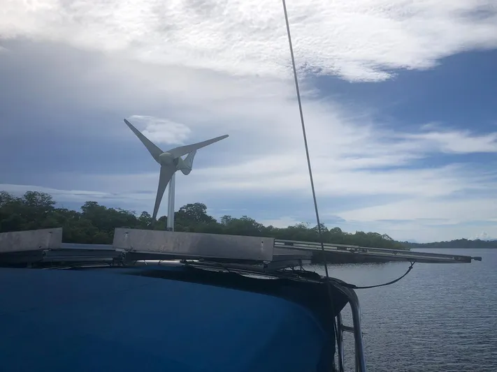Picaro Yacht Photos Pics Beneteau Oceanis 473 sailboat with wind turbine, 2005 model, on calm waters under cloudy sky.