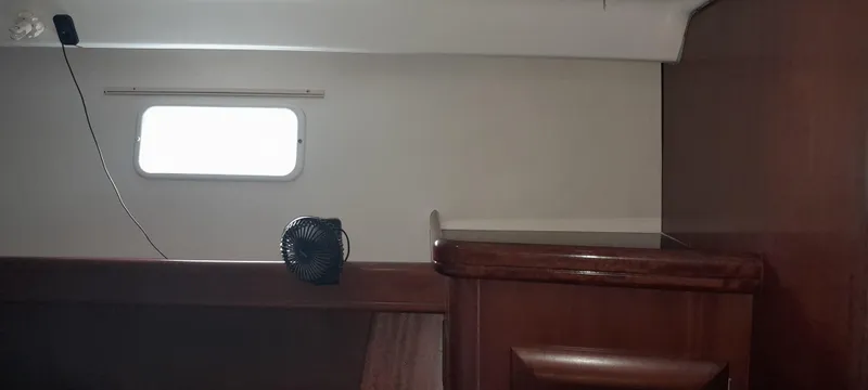 Picaro Yacht Photos Pics Interior of 2005 Beneteau Oceanis 473 sailboat, featuring a small fan and wooden cabinetry.