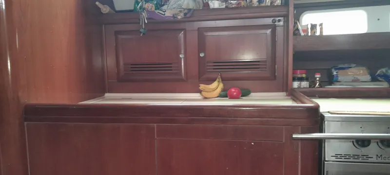 Picaro Yacht Photos Pics Interior of 2005 Beneteau Oceanis 473 yacht kitchen with wooden cabinets and fruit.