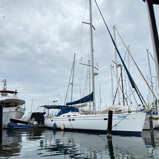 Picaro Yacht Photos Pics 2005 Beneteau Oceanis 473 sailboat docked at marina under cloudy sky.