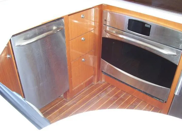  Yacht Photos Pics 1999 Bayliner 5788 Pilot House Motoryacht kitchen with stainless steel appliances and wooden cabinetry.