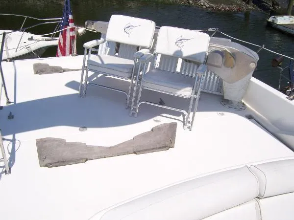  Yacht Photos Pics 1999 Bayliner 5788 Pilot House Motoryacht deck with chairs and American flag.