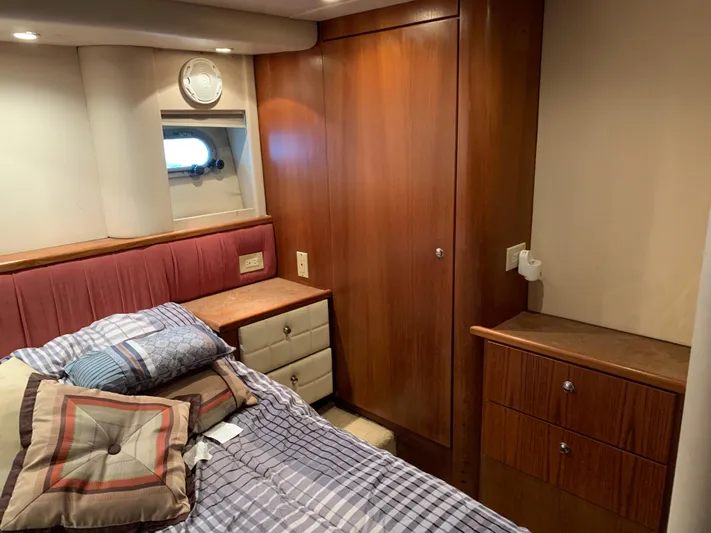  Yacht Photos Pics 1999 Bayliner 5788 Pilot House Motoryacht bedroom with wood cabinetry and cozy bedding.
