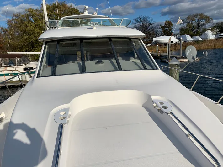  Yacht Photos Pics 1999 Bayliner 5788 Pilot House Motoryacht on water, showcasing sleek design and spacious deck.