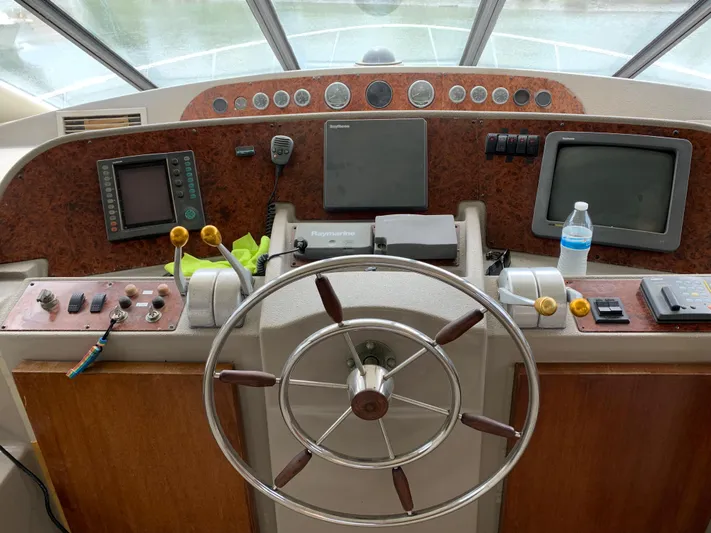  Yacht Photos Pics 1999 Bayliner 5788 Pilot House Motoryacht helm with steering wheel and navigation equipment.