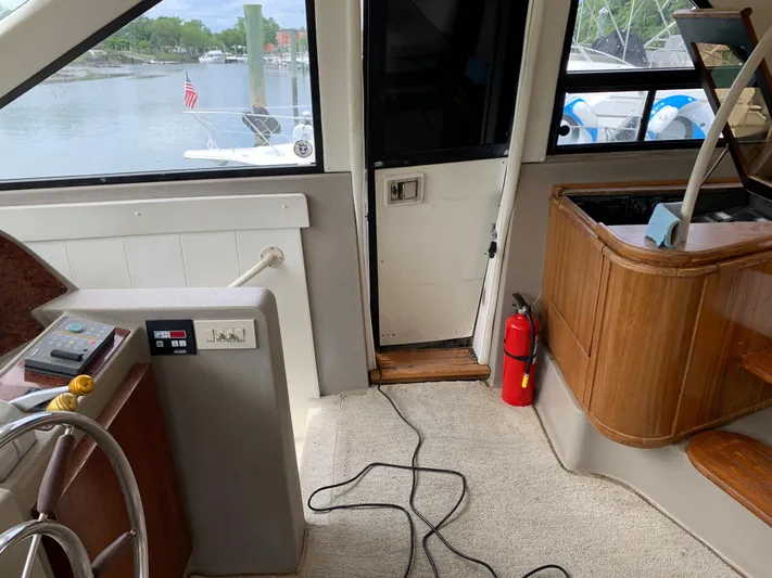  Yacht Photos Pics 1999 Bayliner 5788 Pilot House Motoryacht interior with helm, stairs, and fire extinguisher.